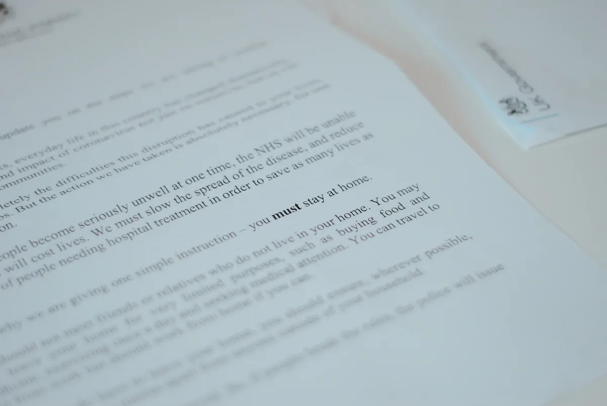 Empty office desk with a crumpled job application rejection letter and a closed laptop in soft light