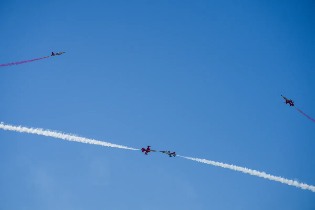 Gökyüzünde uçan askeri savaş uçağı formasyonu, küresel savunma harcamalarının artışını temsil ediyor.
