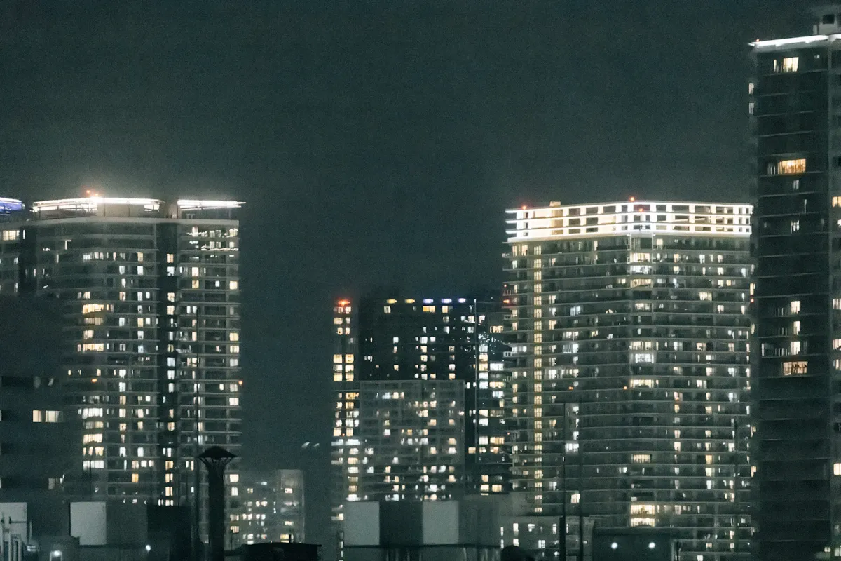 Glowing phone screen illuminating a dark room near a window with nighttime city lights