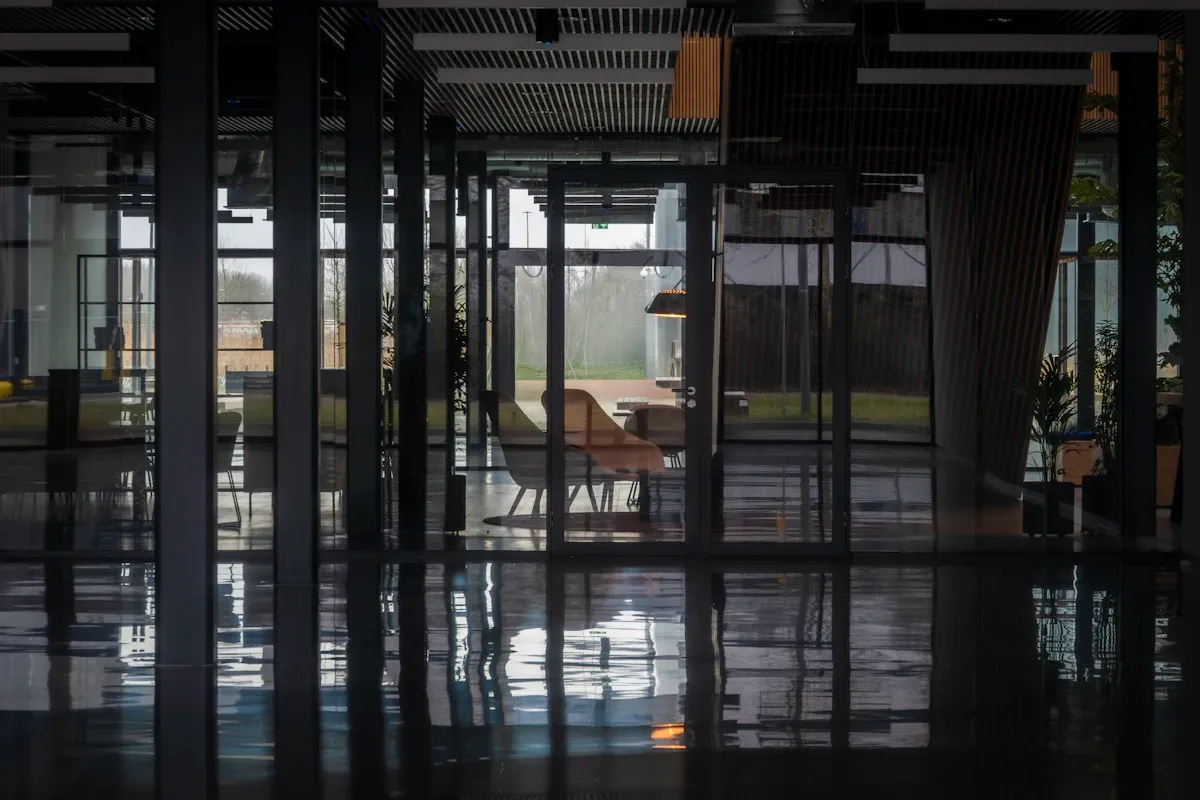 Modern ve minimalist ofis çalışma alanı, boş masa ve düzenli dizilmiş ekranlarla teknoloji odaklı iş ortamını yansıtıyor.