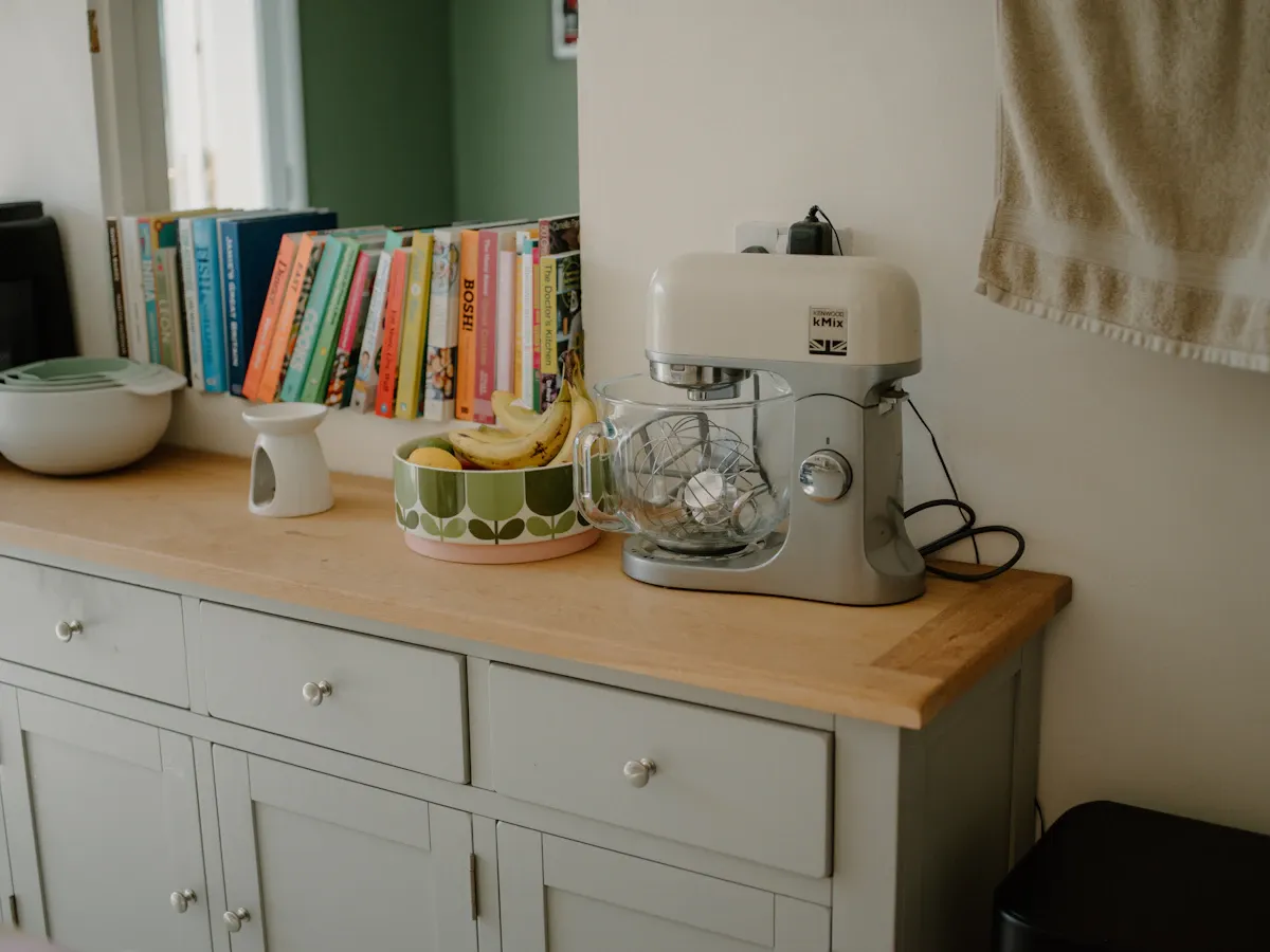 Electric vegetable chopper on a modern kitchen countertop surrounded by organized cooking gadgets
