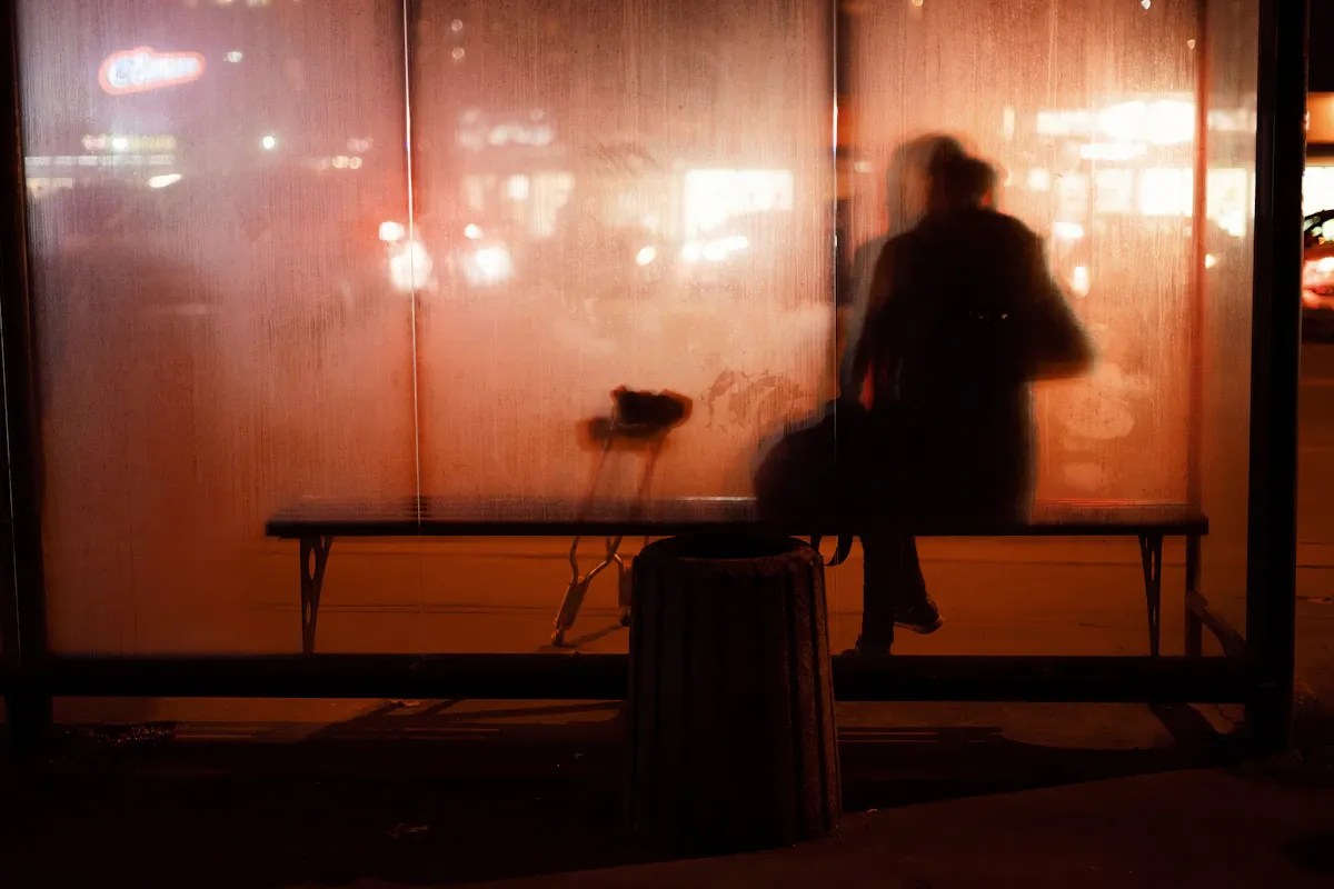 Yalnız bir insan silueti, yalnızlık salgını ve sosyal izolasyon krizini temsil eden karanlık bir arka plan üzerinde.